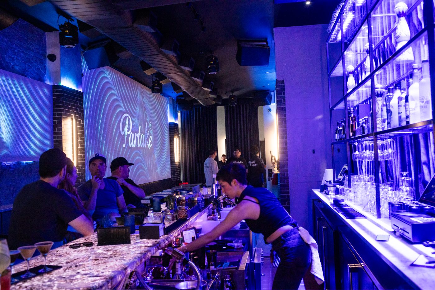 Bartenders at work behind the marble bar