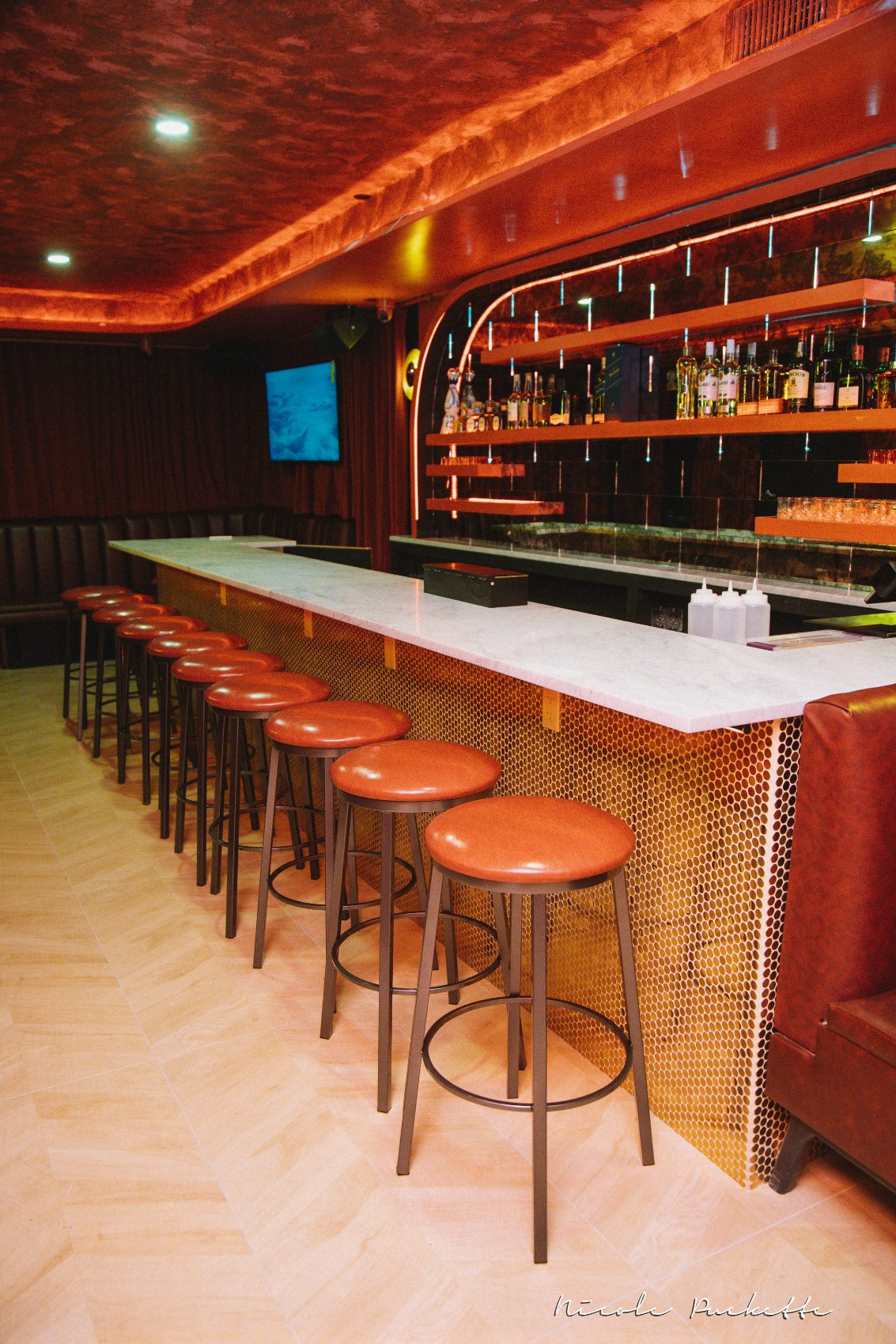 The Red Room private bar at Partake NYC with marble top, penny tile and leather stools