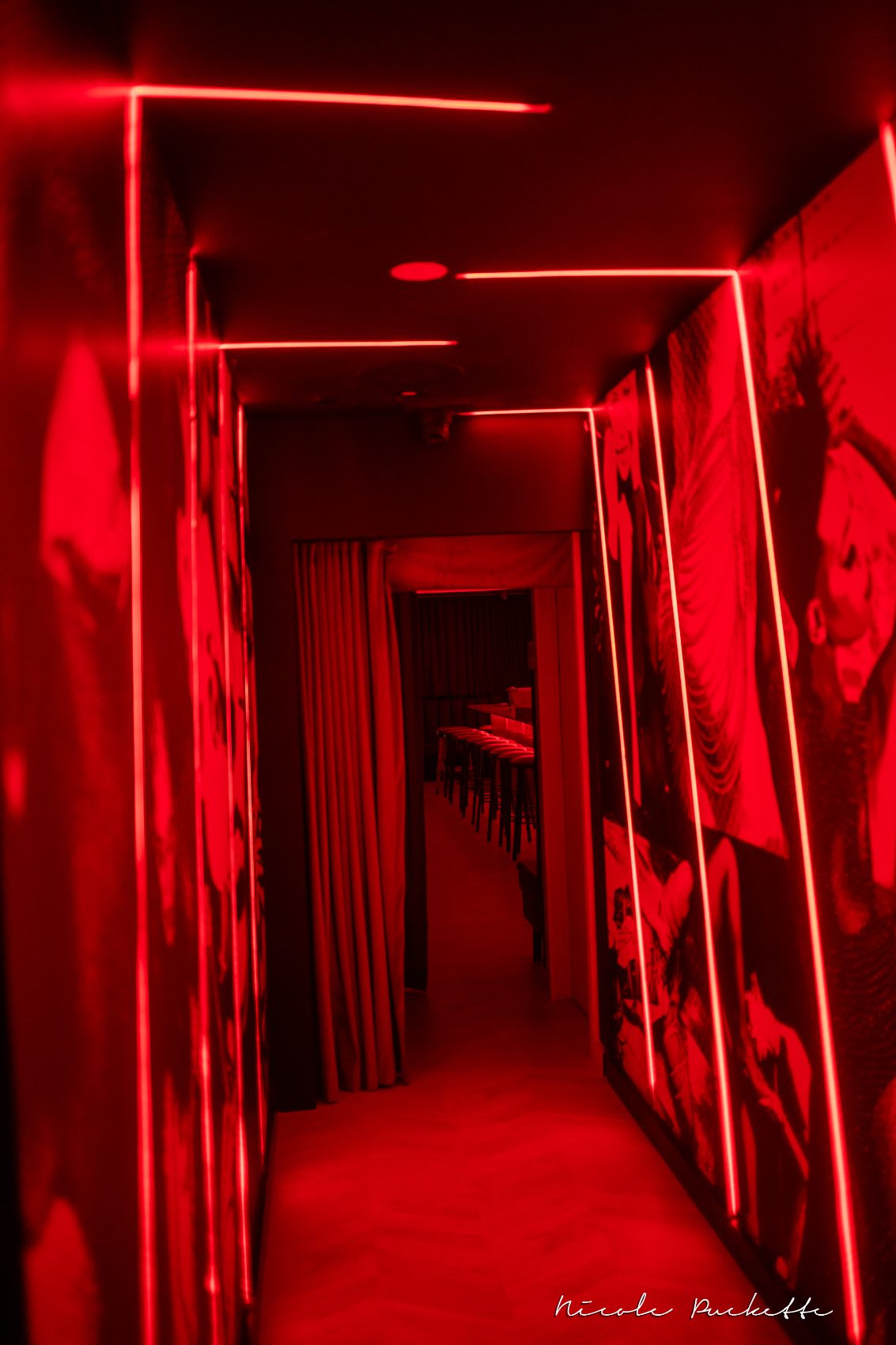Red-lit corridor leading to the Red Room bar at Partake NYC